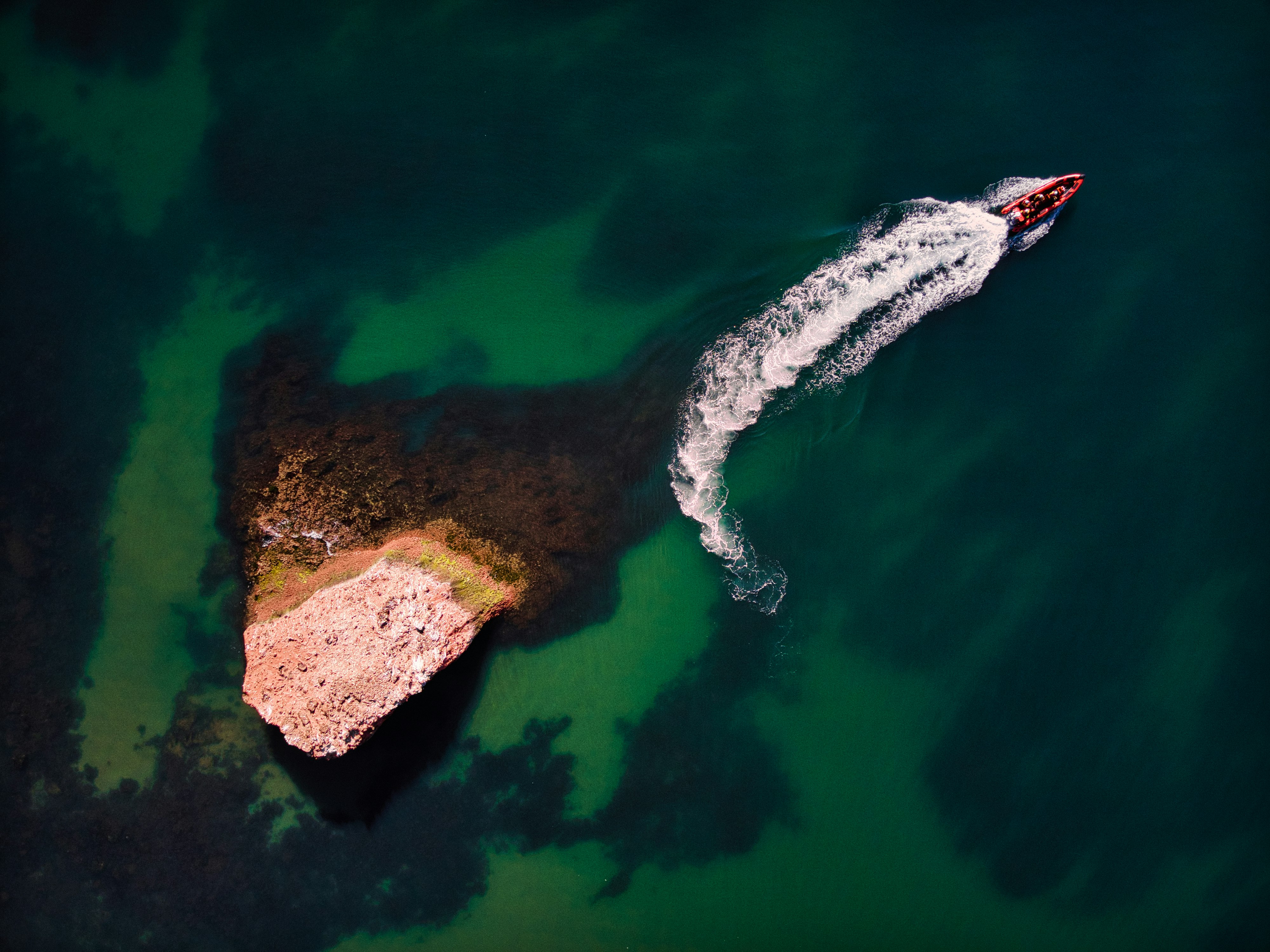 aerial view of brown rock formation on body of water during daytime